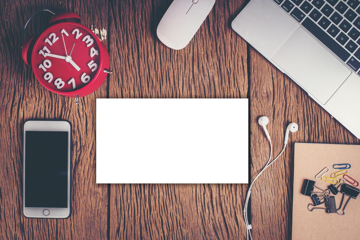 Top view phone and workspace on wood background. photo