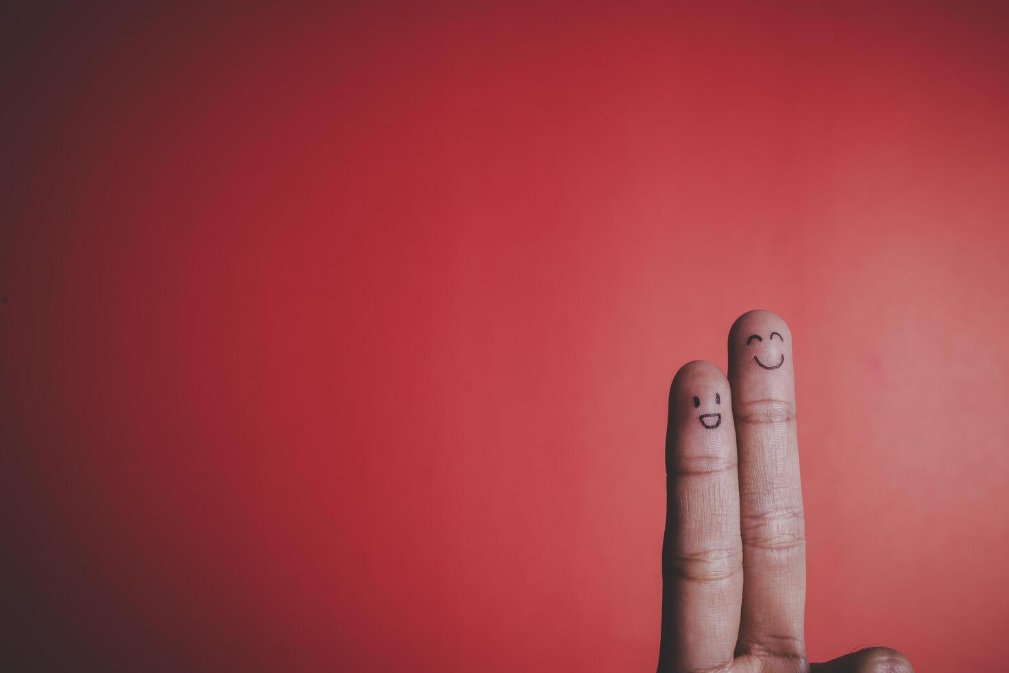 Finger with emotion on red background. photo