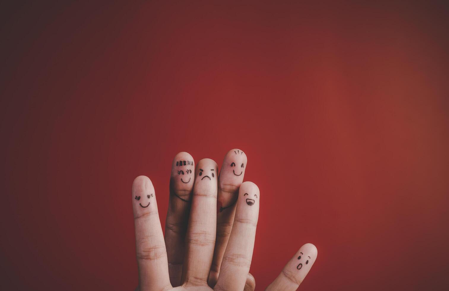 Finger with emotion on red background. photo