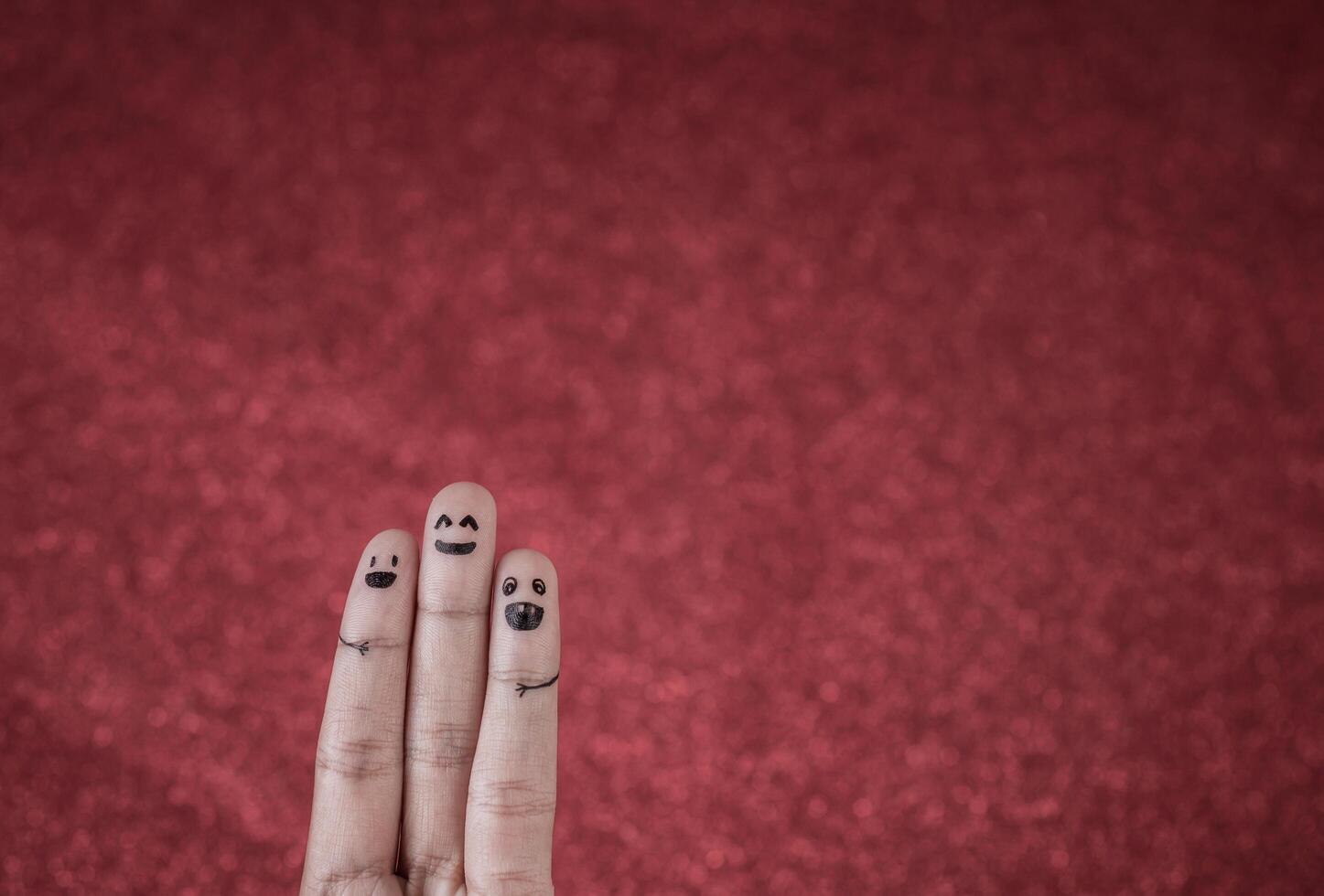 Finger with emotion on red background. photo