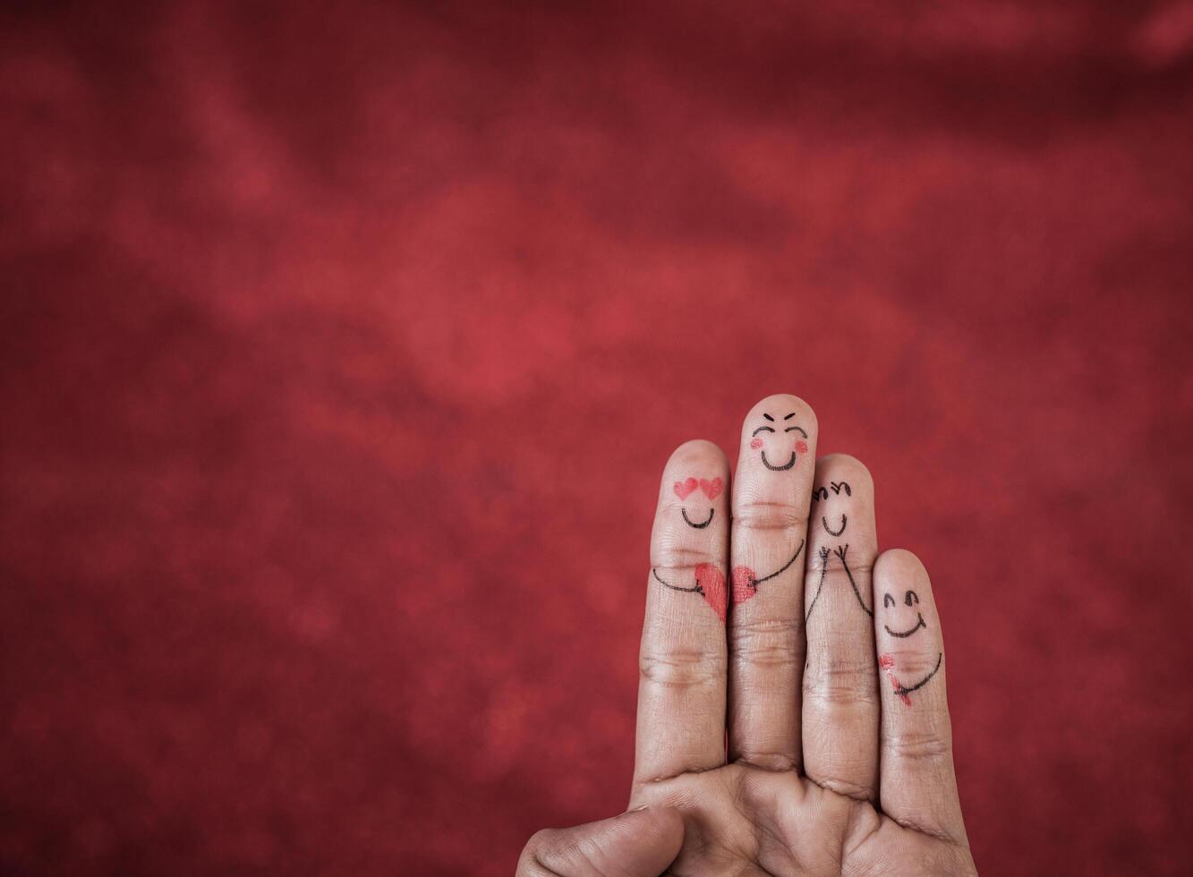 Finger with emotion on red background. photo