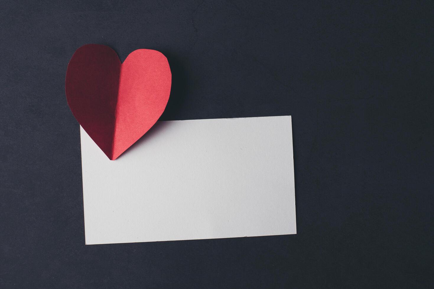Heart and blank with note card on Red background. photo