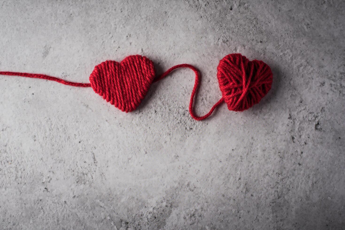 Hilo rojo en forma de corazón en el fondo de la pared. foto