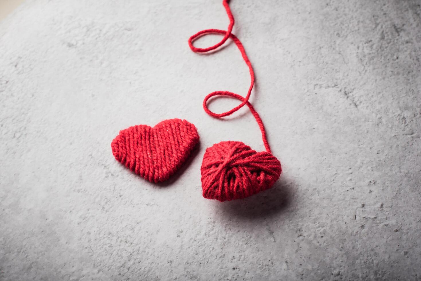 Hilo rojo en forma de corazón en el fondo de la pared. foto