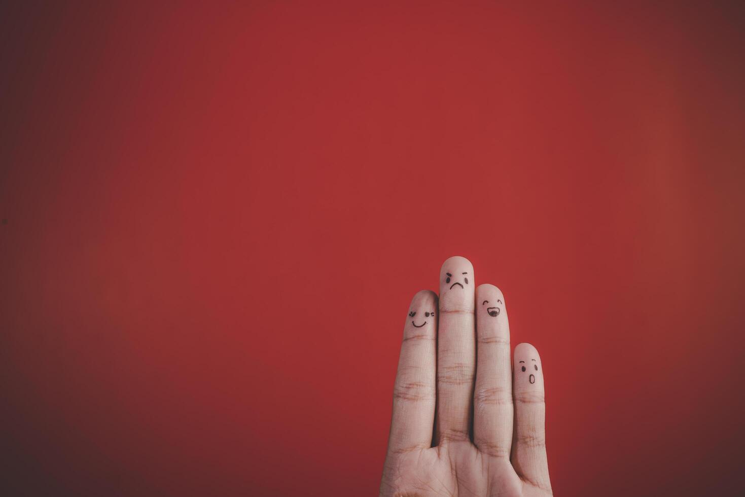 Finger with emotion on red background. photo