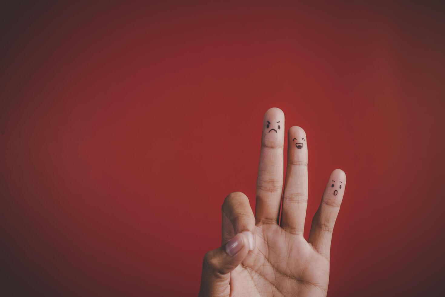 Finger with emotion on red background. photo