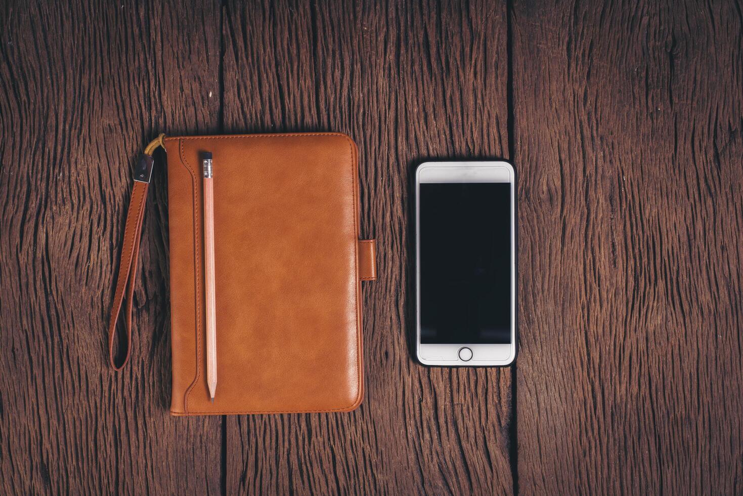 Top view Tablet computer and phone on wood background. photo