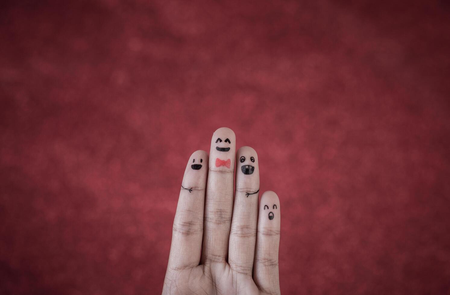 Finger with emotion on red background. photo