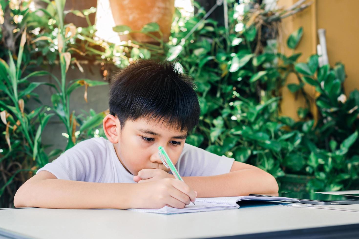 lindo asiático adolescente haciendo su tarea foto