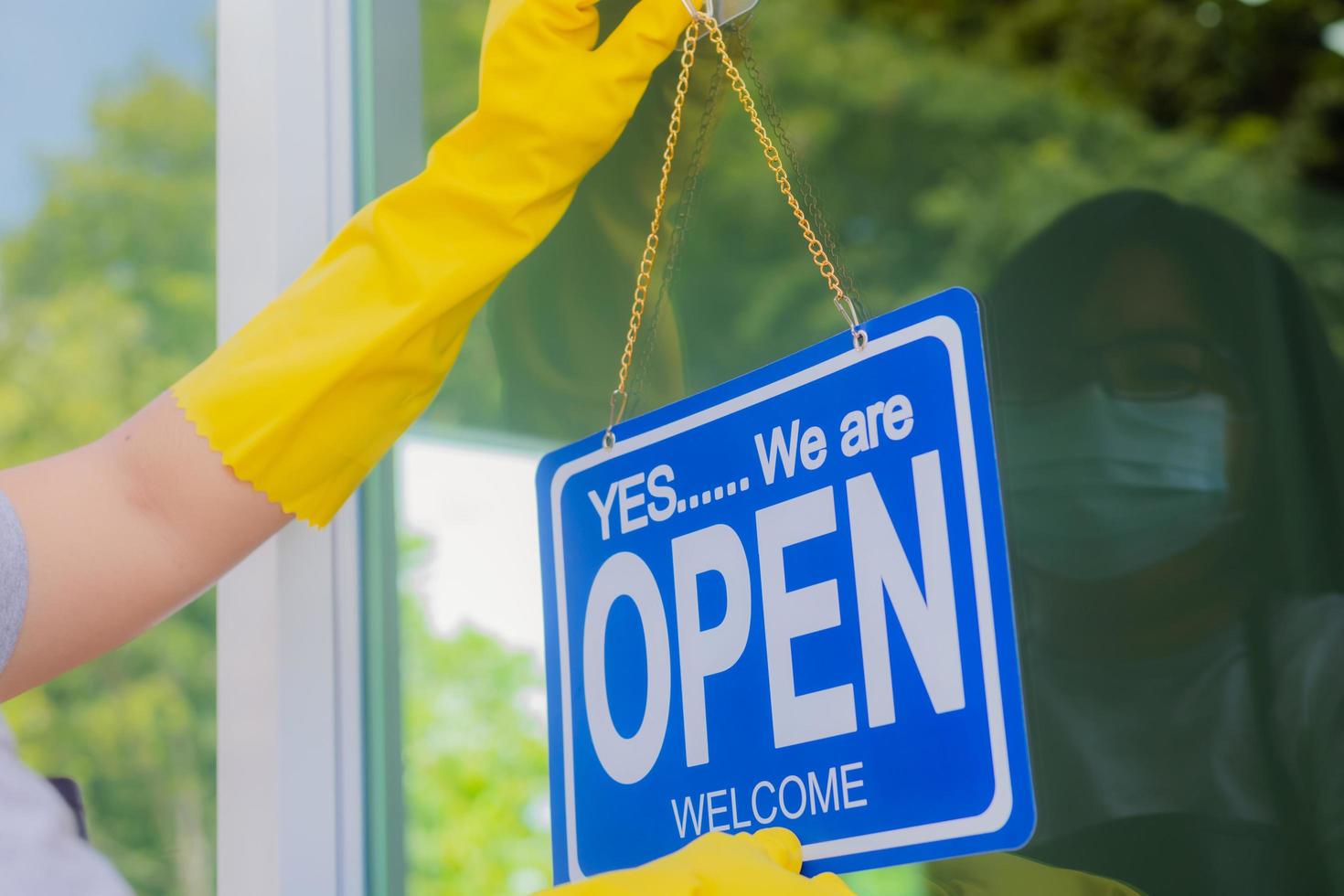 The owner of the store hangs a sign to open a business in front photo