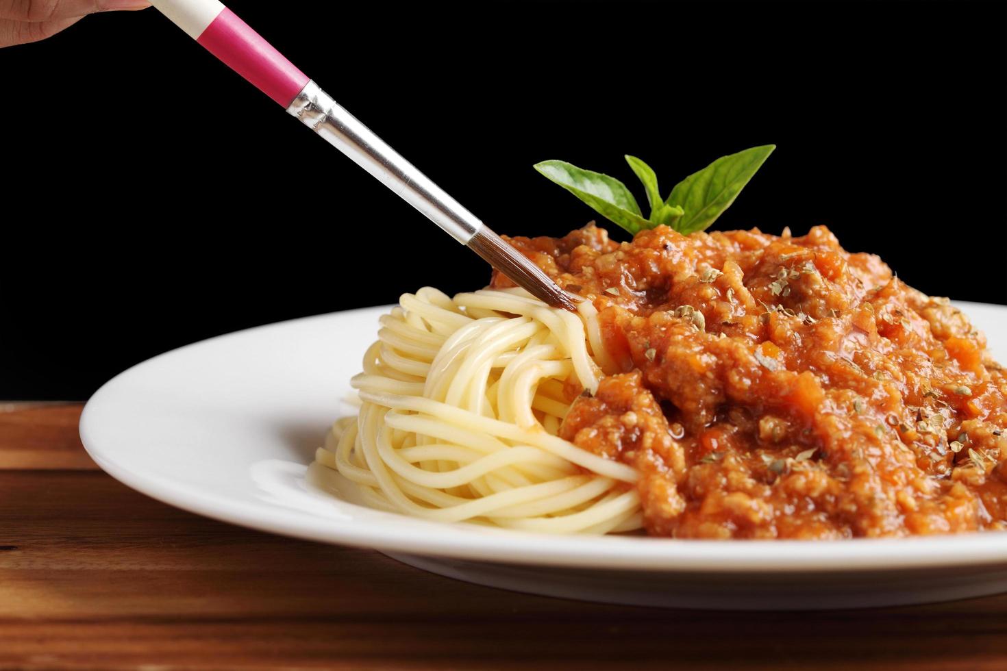 El estilista de alimentos utiliza un pincel para decorar la comida italiana. foto