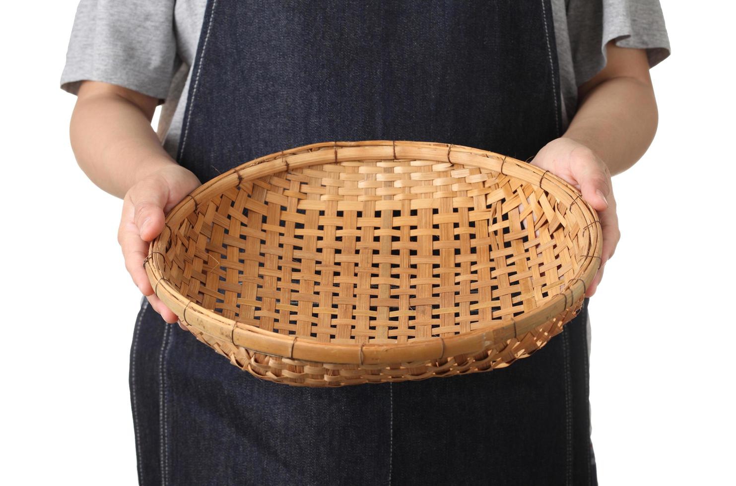 Chef sosteniendo una cesta de madera sobre fondo blanco. foto