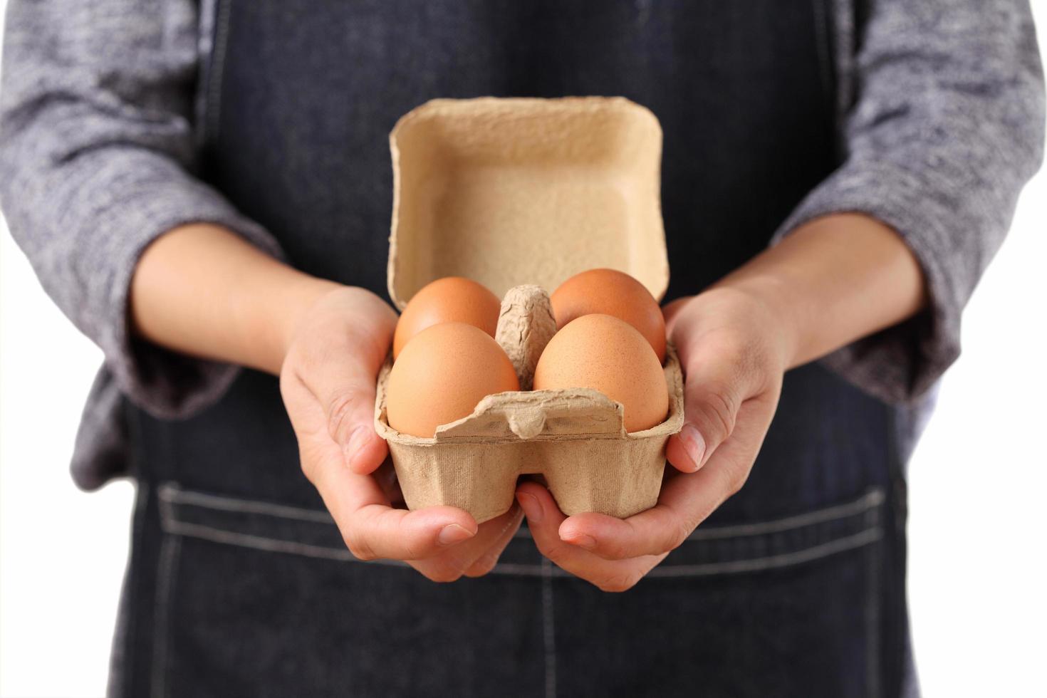 Woman holding fresh chicken eggs in cardboard box photo