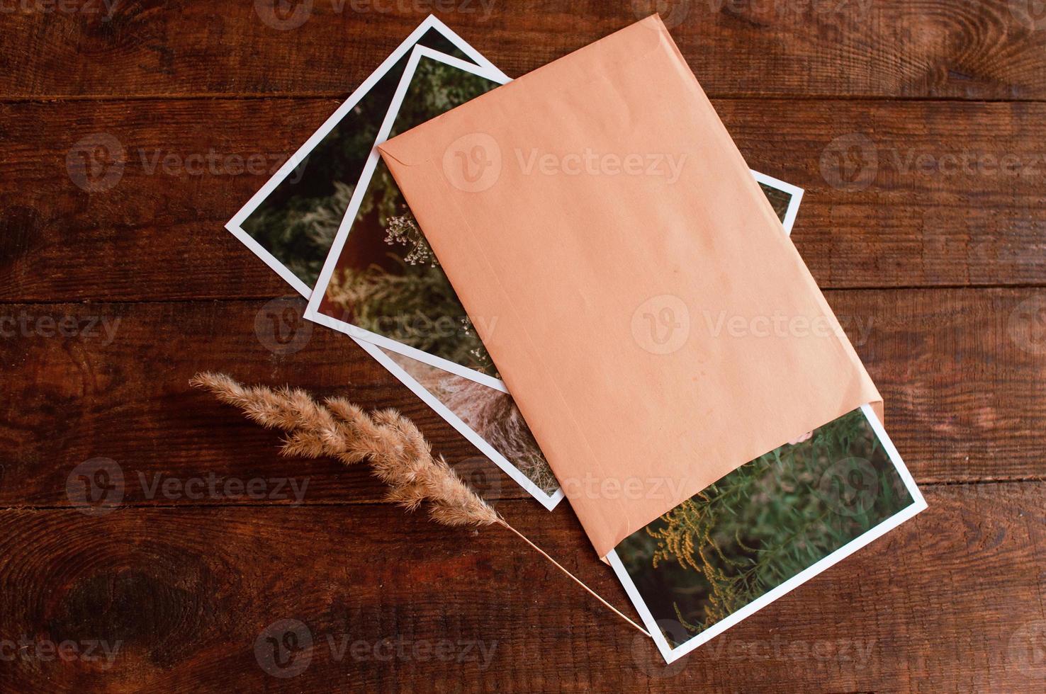 Composition with photo embedded in beige envelope lies on wooden table