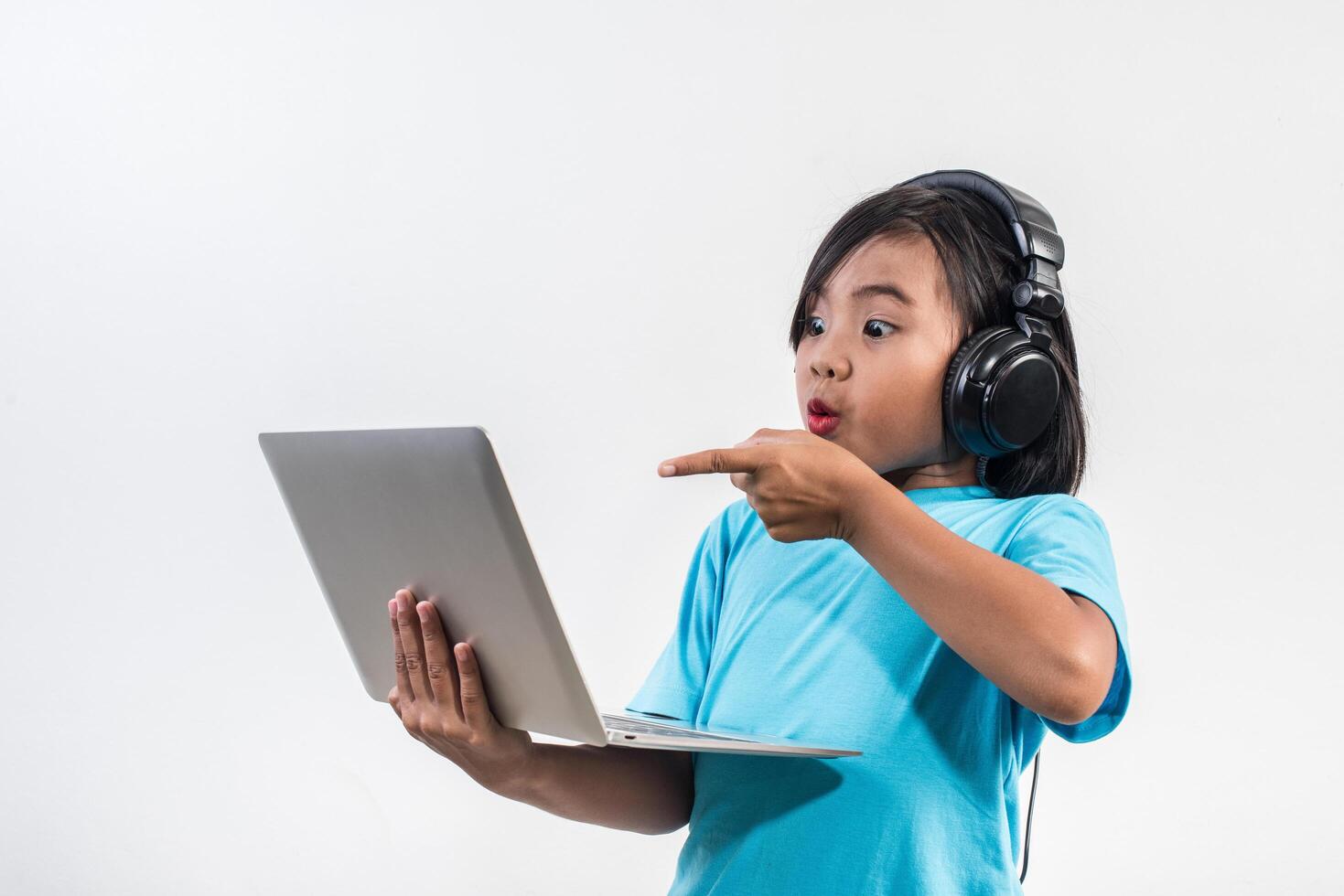 niña usando computadora portátil y lección de escucha en línea. foto