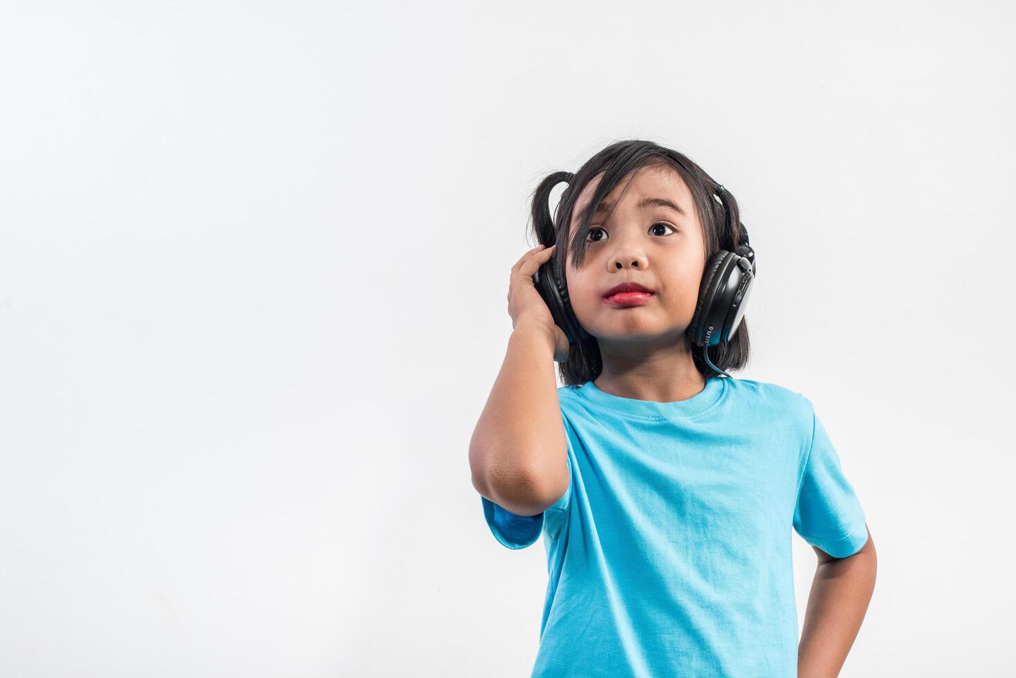 Little girl listening to music on wireless headphones. photo