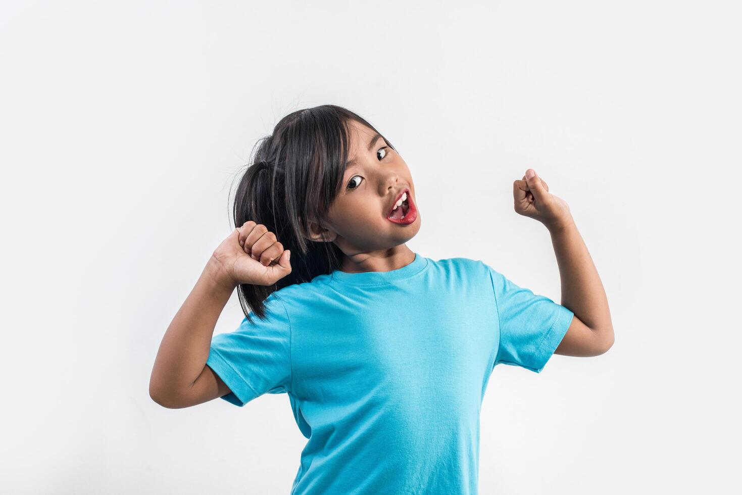 Portrait of Funny little girl acting in studio shot. photo