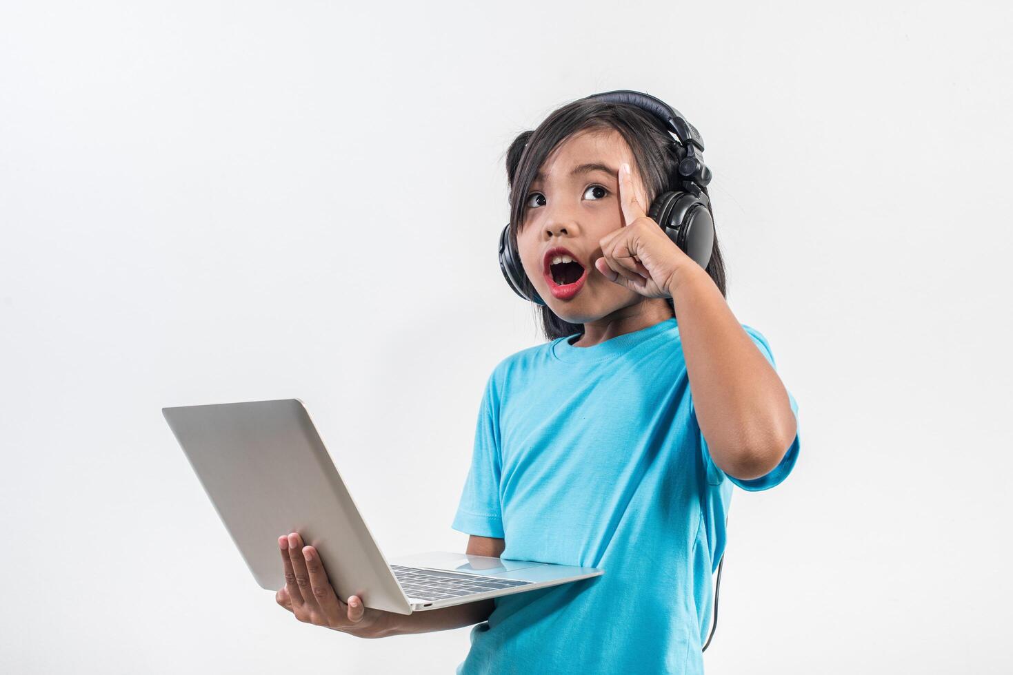 Little girl using laptop computer and listening lesson online. photo