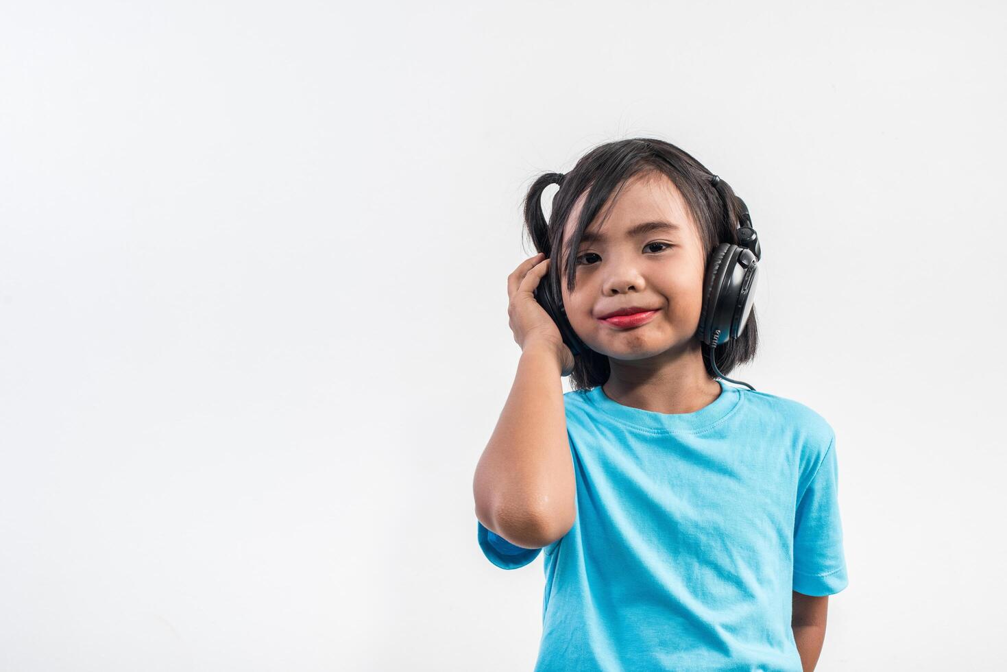 Little girl listening to music on wireless headphones. photo