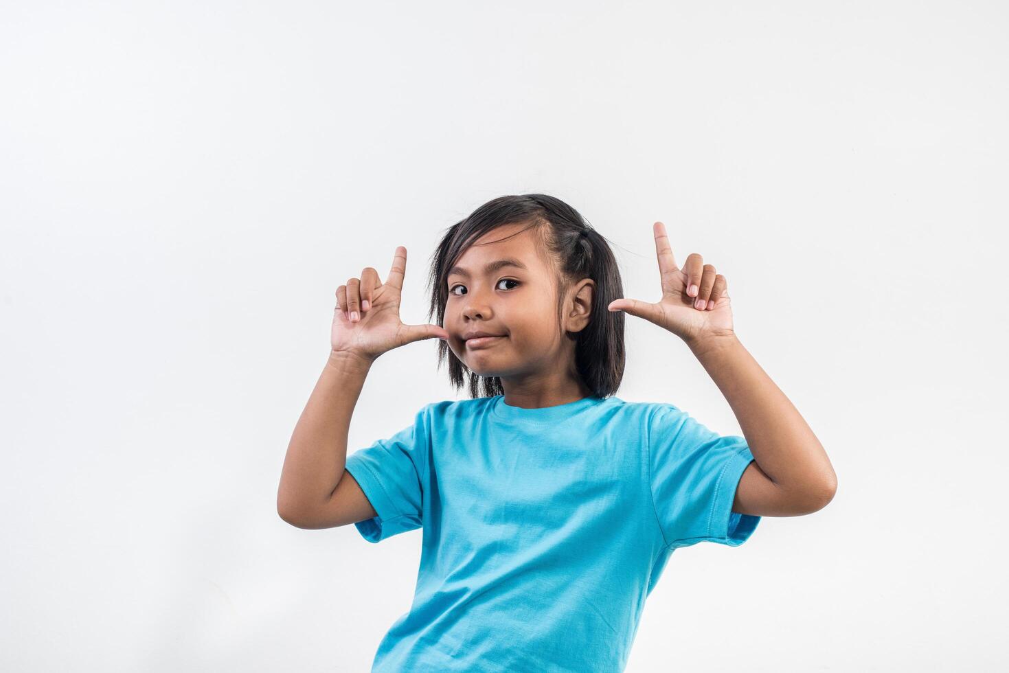 Retrato de niña divertida actuando en tiro de estudio. foto