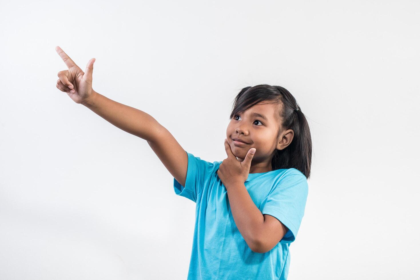 Portrait of Funny little girl acting in studio shot. photo