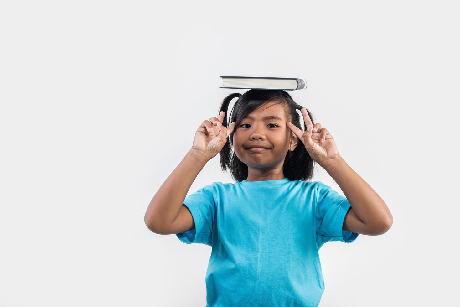 Little girl reading book in studio shot. photo