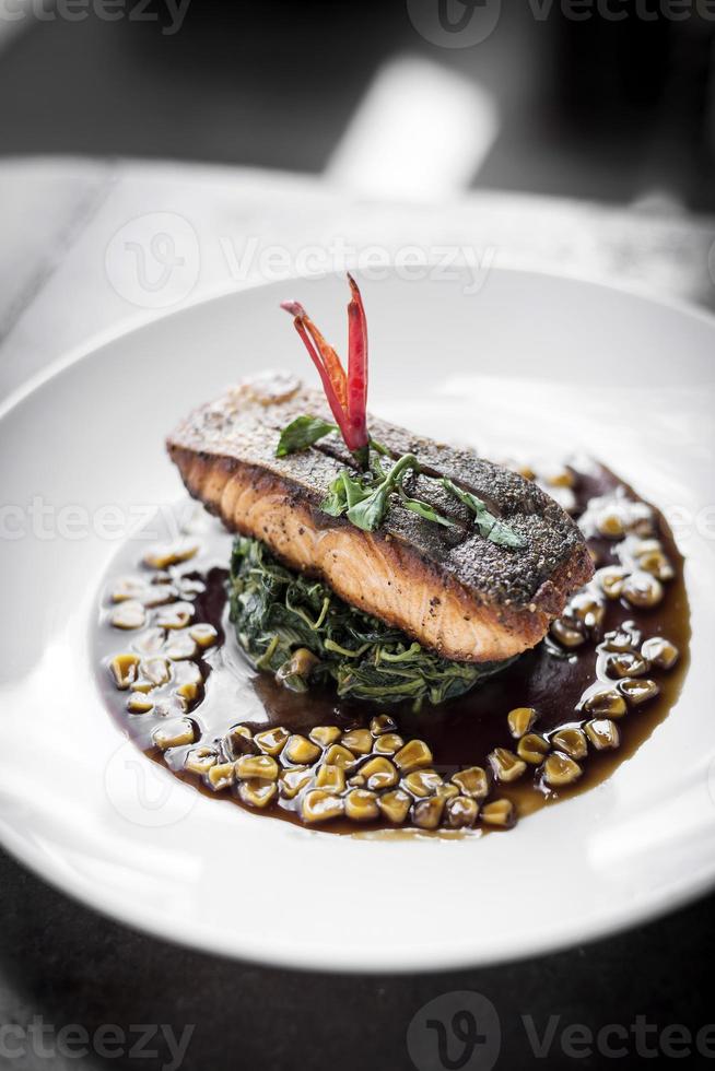 filete de salmón con espinacas al vapor y maíz con salsa dulce de soja y ostras foto