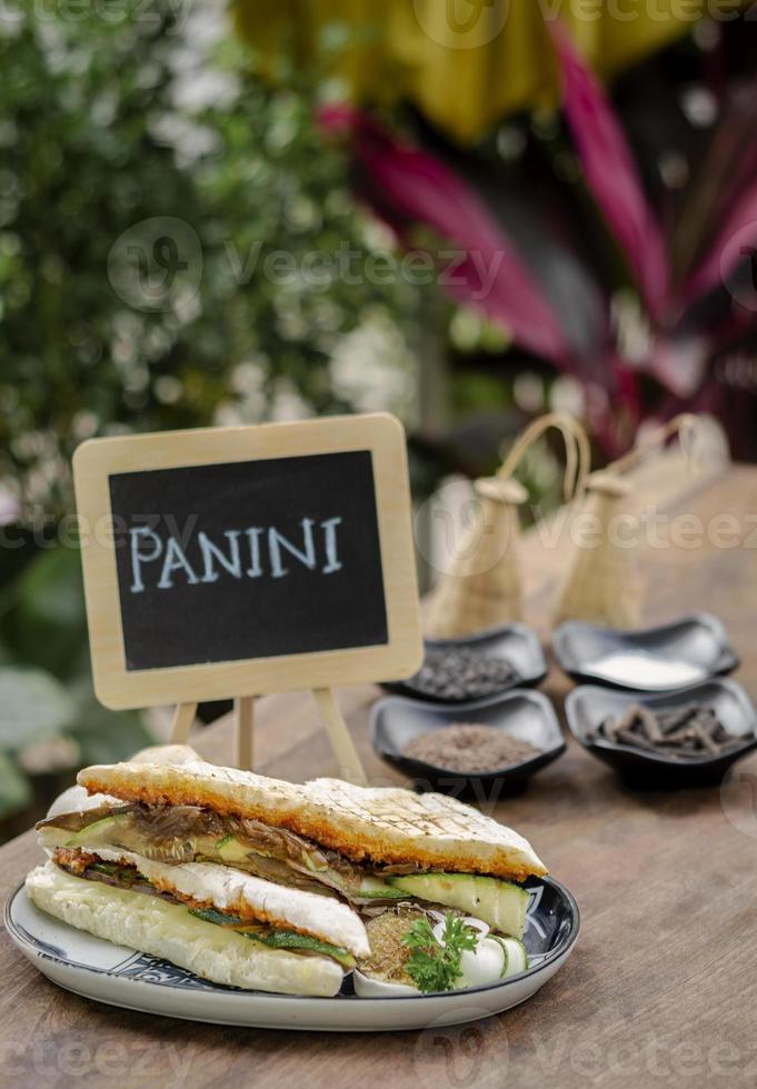 Vegan roasted vegetable toasted panini sandwich in rustic garden table setting outdoors in Sicily photo