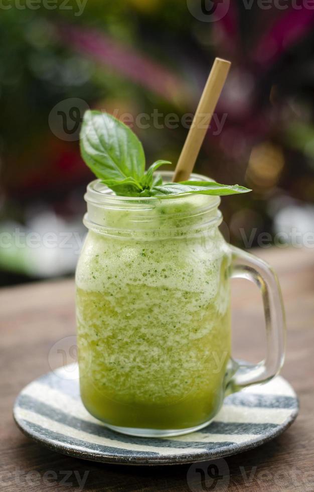 Organic pineapple kiwi and basil fruit detox healthy smoothie drink outdoors in glass photo