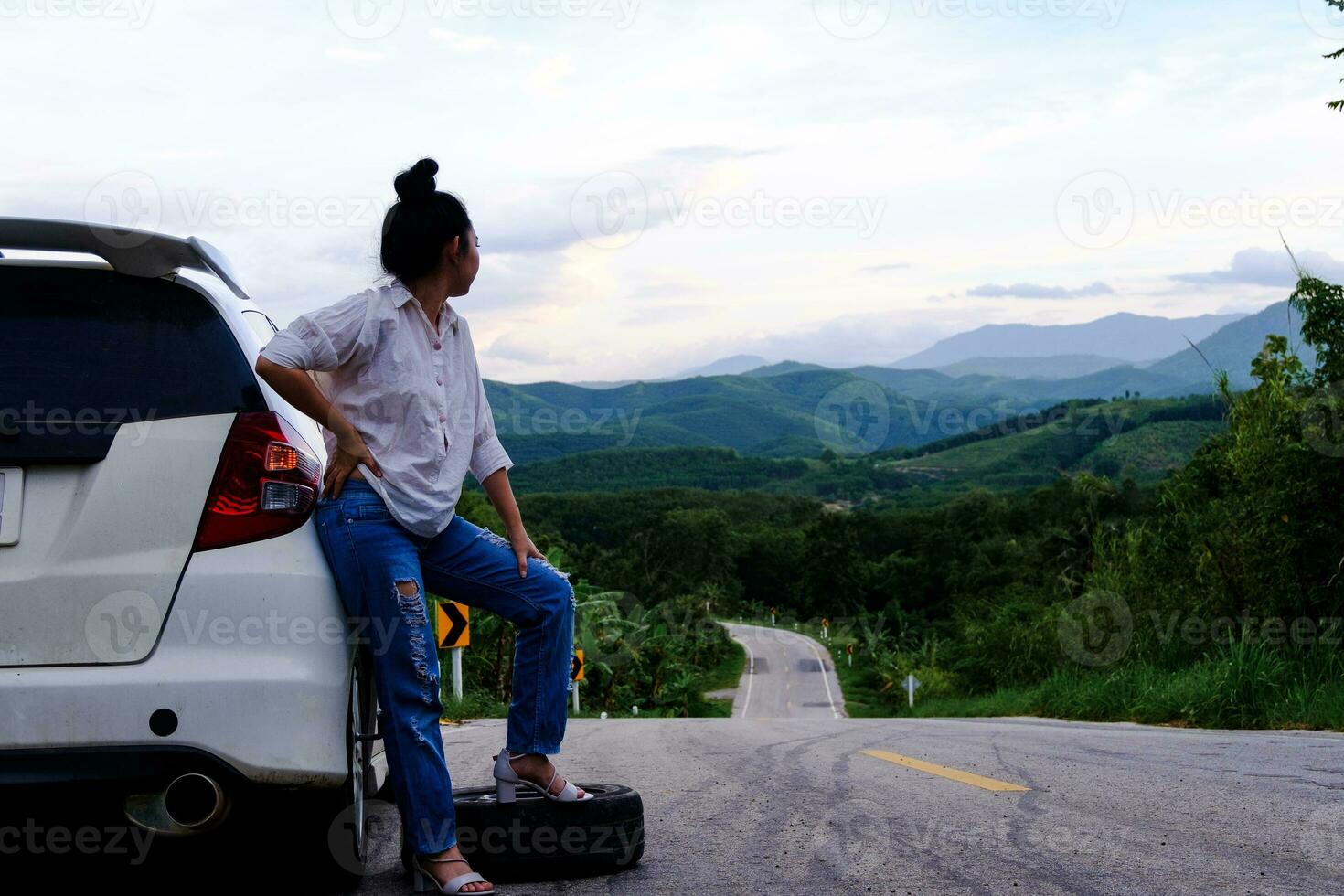 Young Asian woman sanding near the car waiting for help photo