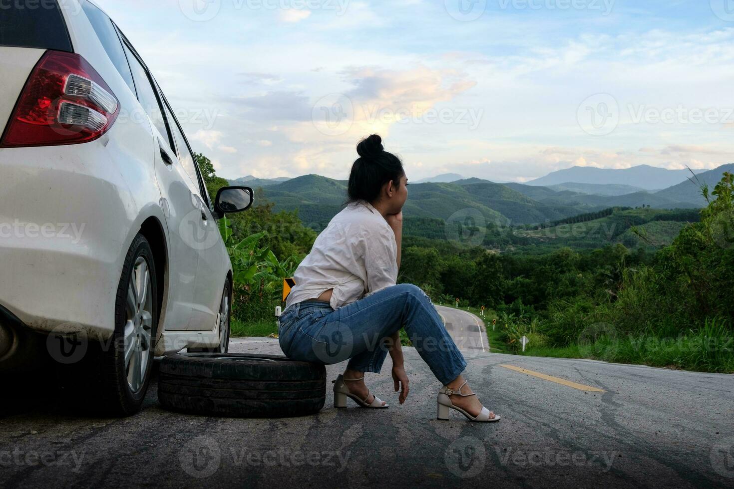 Young Asian woman siting near the car waiting for help photo