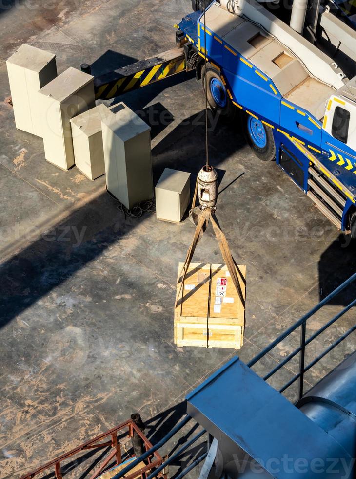 Crane lifting the radioactive instrument transportation wooden box photo