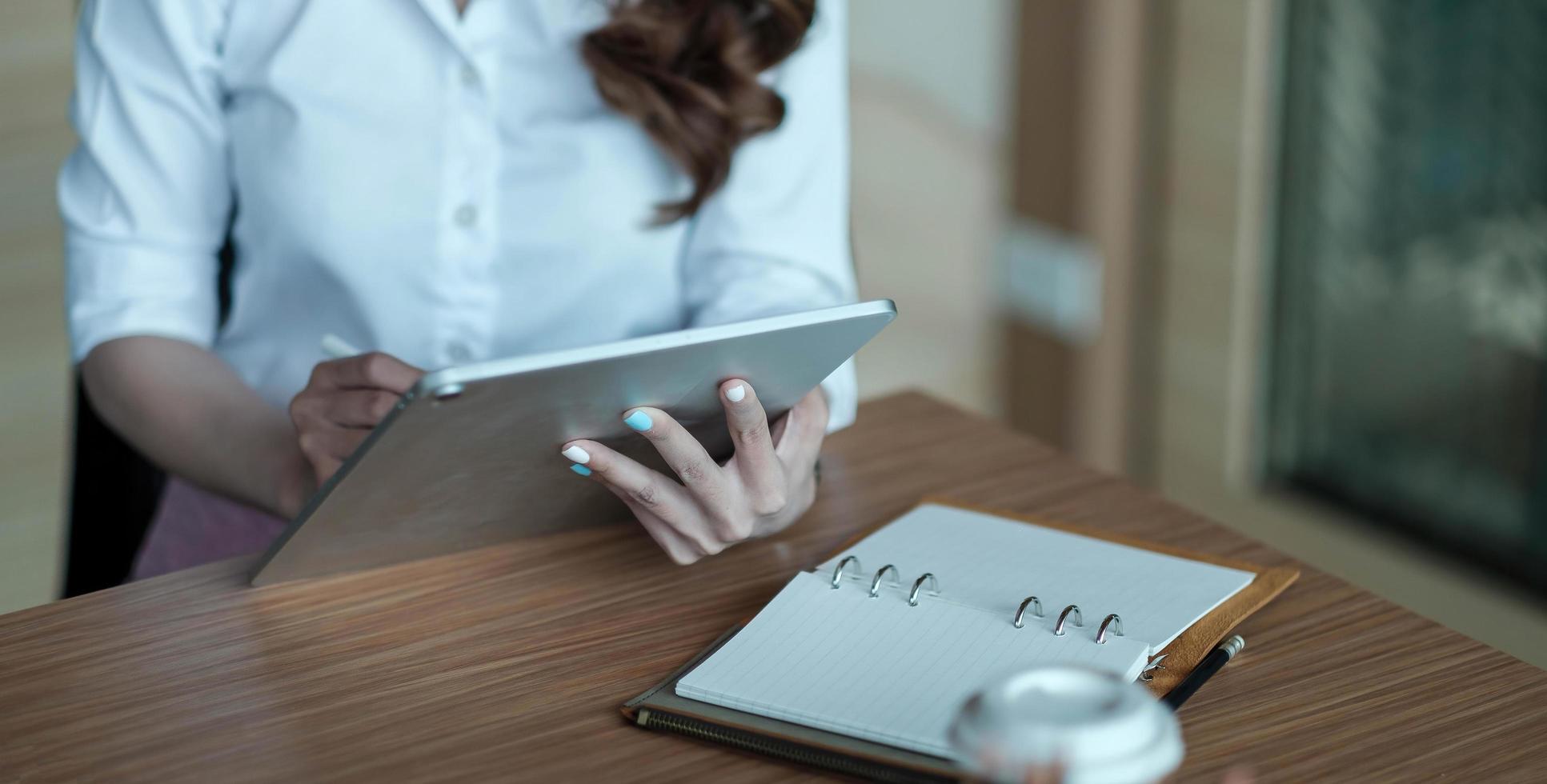 Close up hand of woman using digital tablet with touch screen photo