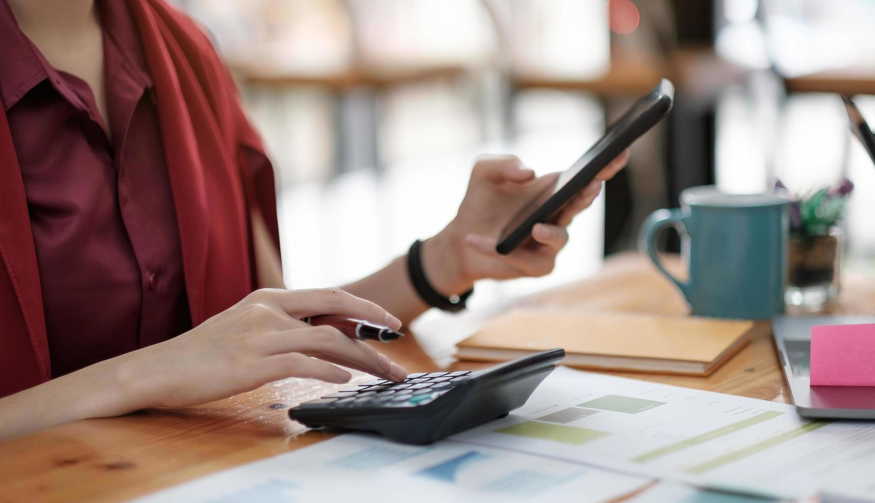 Close up Business woman using calculator and laptop for do math photo