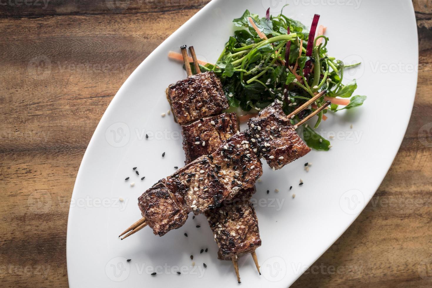 Asian spicy sweet soy sauce and sesame seed grilled barbecue pork skewers in Singapore restaurant photo