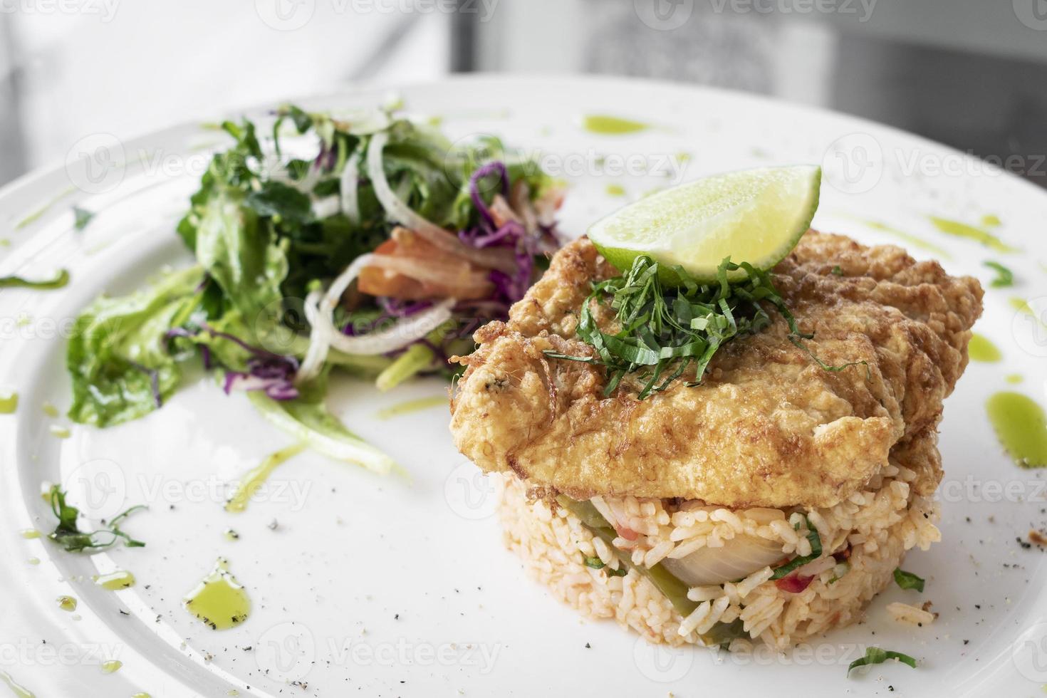 Fresh fried battered cod fish fillet summer light lunch meal with basque mixed vegetable spicy rice and salad photo