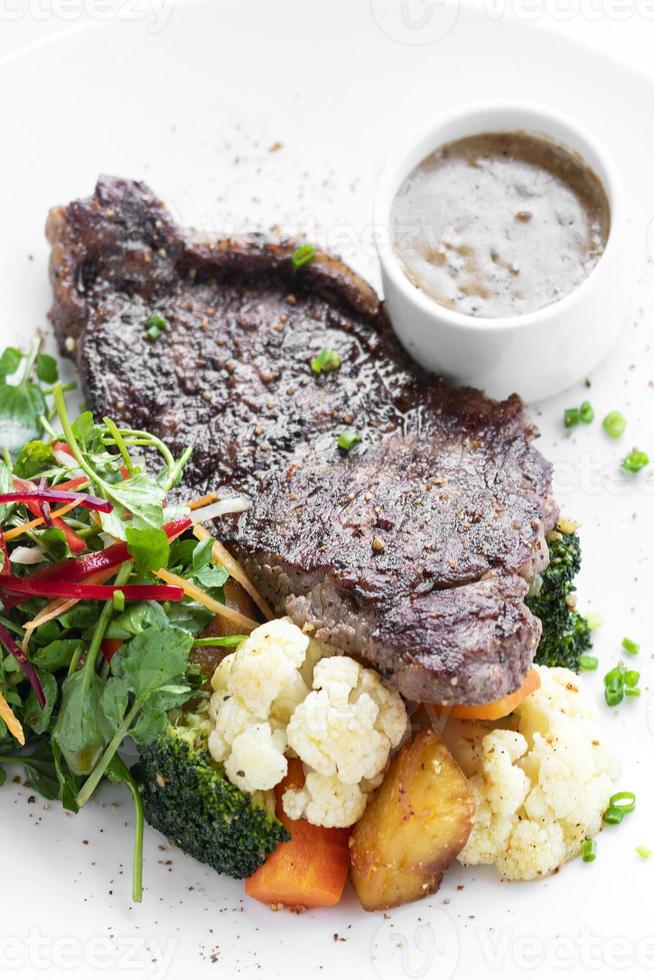 Filete de ternera premium con verduras al vapor y salsa de champiñones comida gourmet en la placa blanca. foto