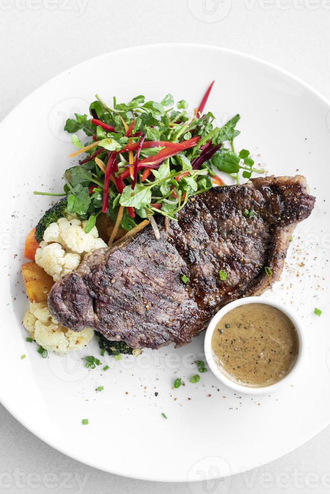 Premium beef steak with steamed vegetables and mushroom sauce gourmet meal on white plate photo