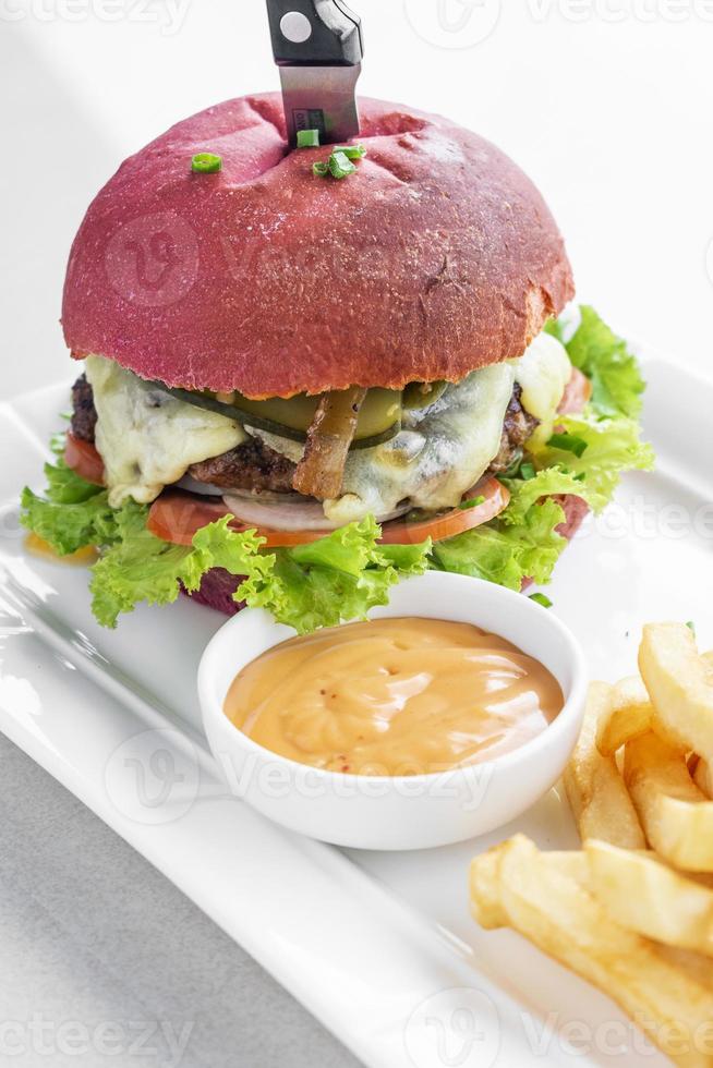 Beetroot red bun cheese burger snack set with fries and chili mayo on white plate photo