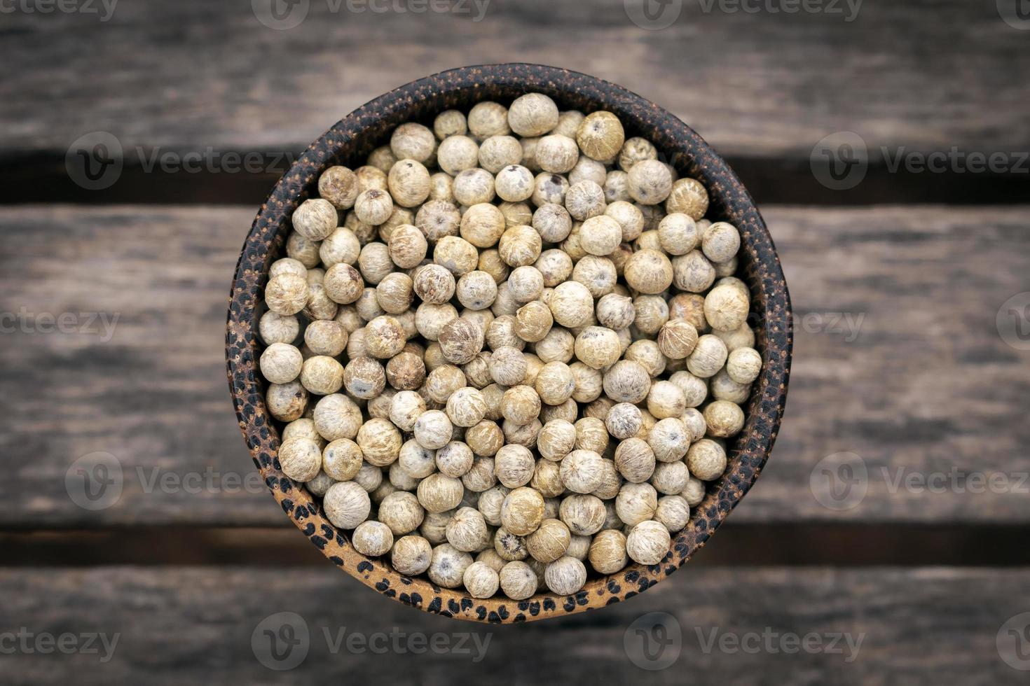 Organic kampot dried white pepper corns in Cambodia in Traditional Asian wood bowl photo