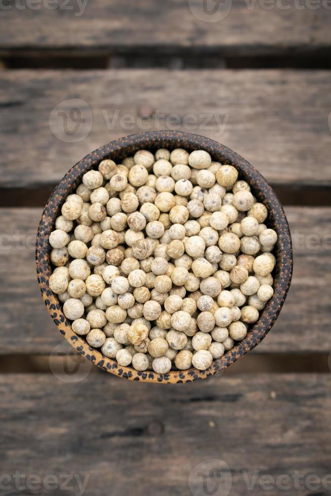 Organic kampot dried white pepper corns in Cambodia in Traditional Asian wood bowl photo