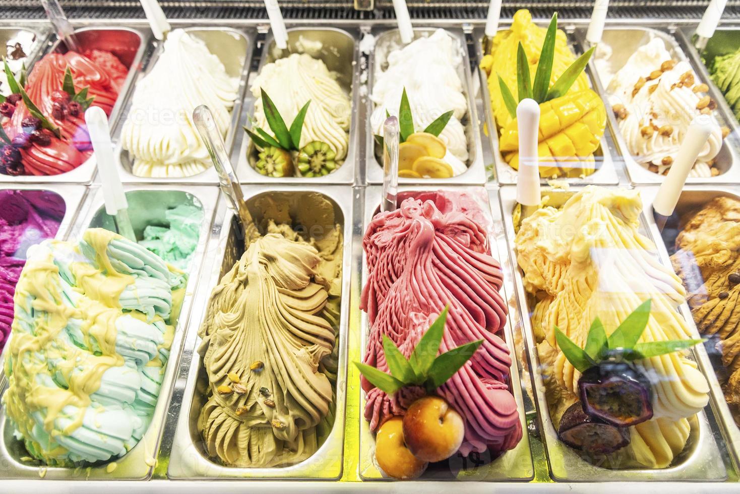 Varios sabores de helado de helado italiano en la ventana de visualización de la tienda moderna foto