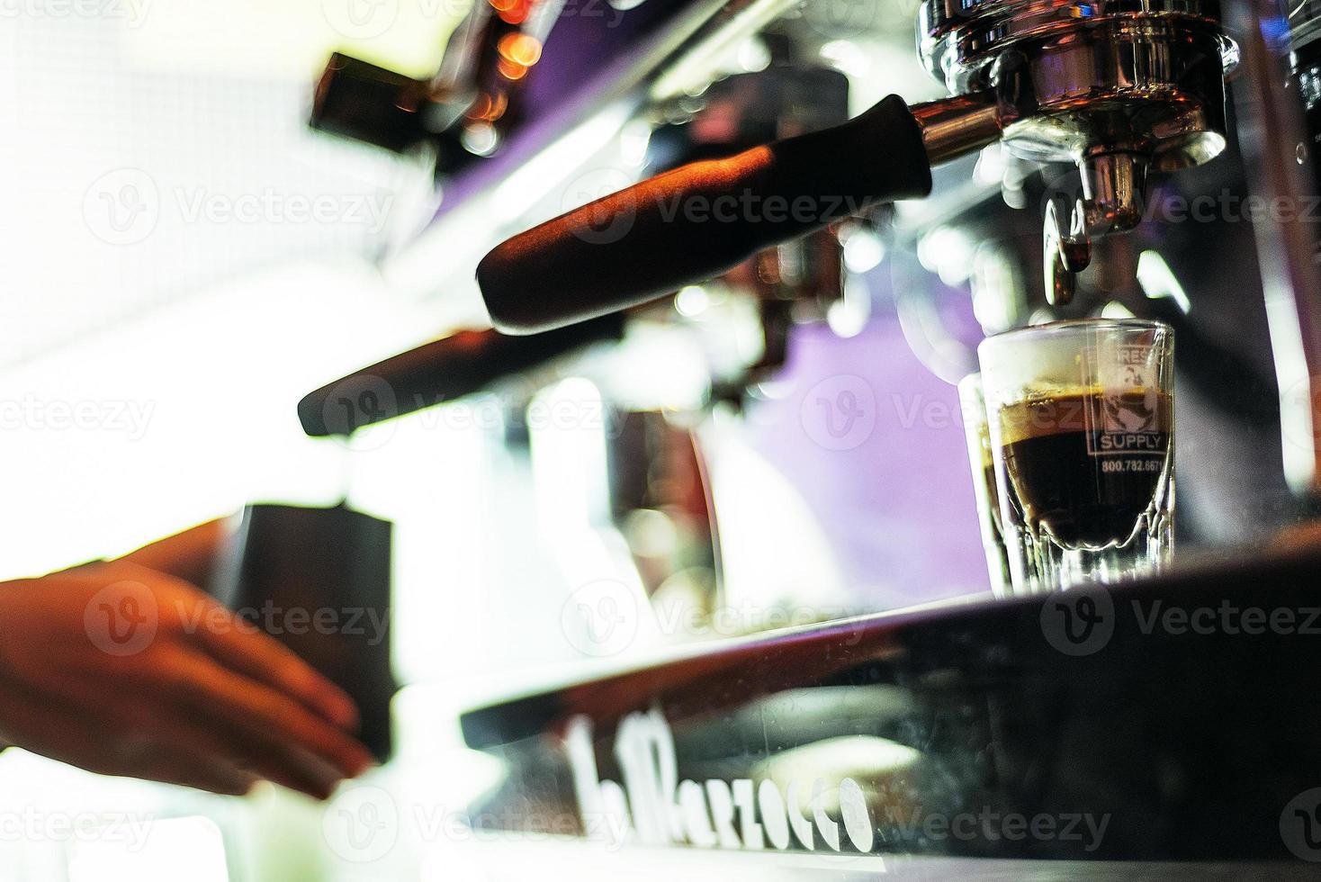 Hacer café espresso de cerca los detalles con la moderna máquina de café foto