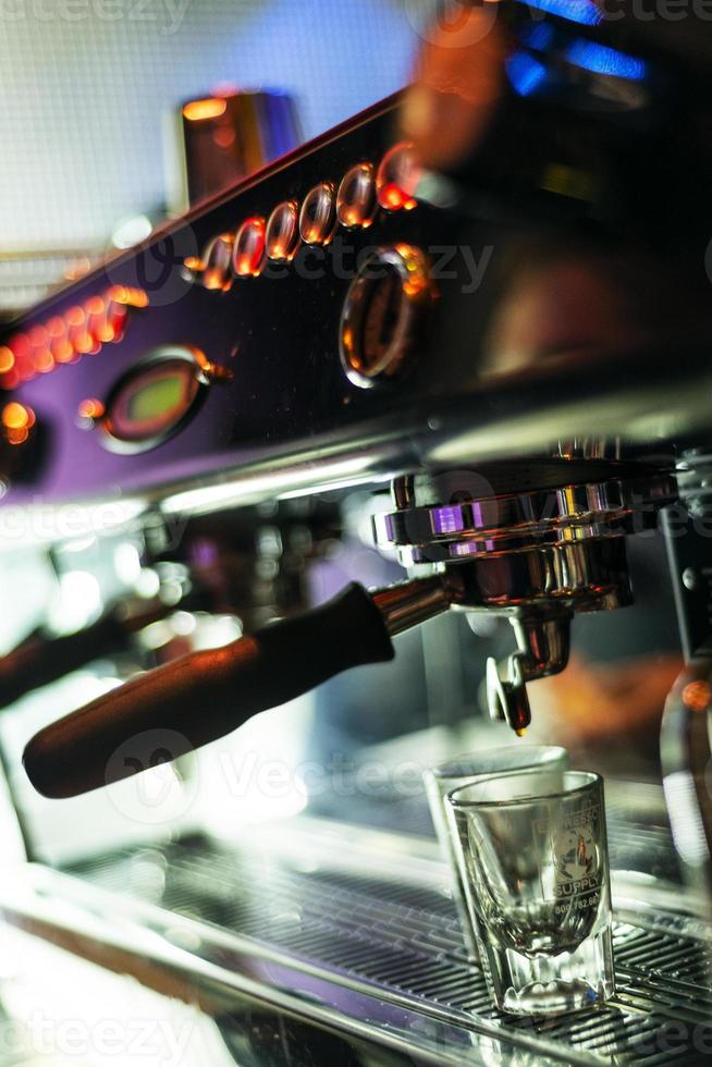 Hacer café espresso de cerca los detalles con la moderna máquina de café foto