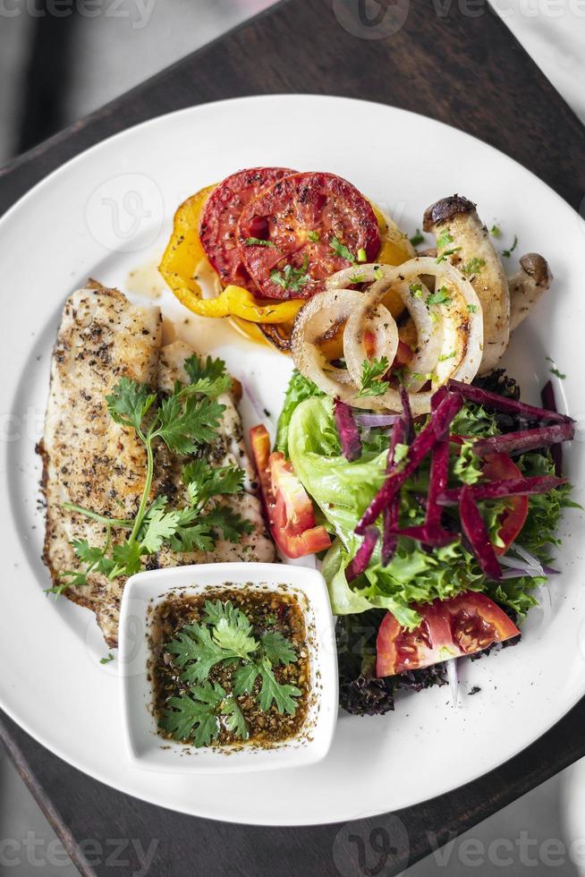 Filete de tilapia con ensalada mixta de verduras a la plancha y vinagreta de hierbas foto