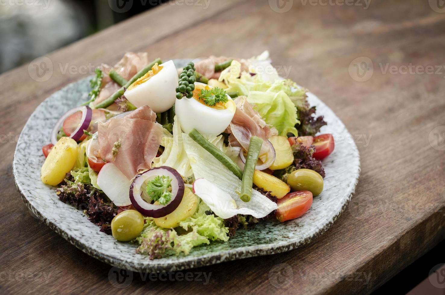 Nicoise style healthy organic rustic salad with egg and ham outdoors photo
