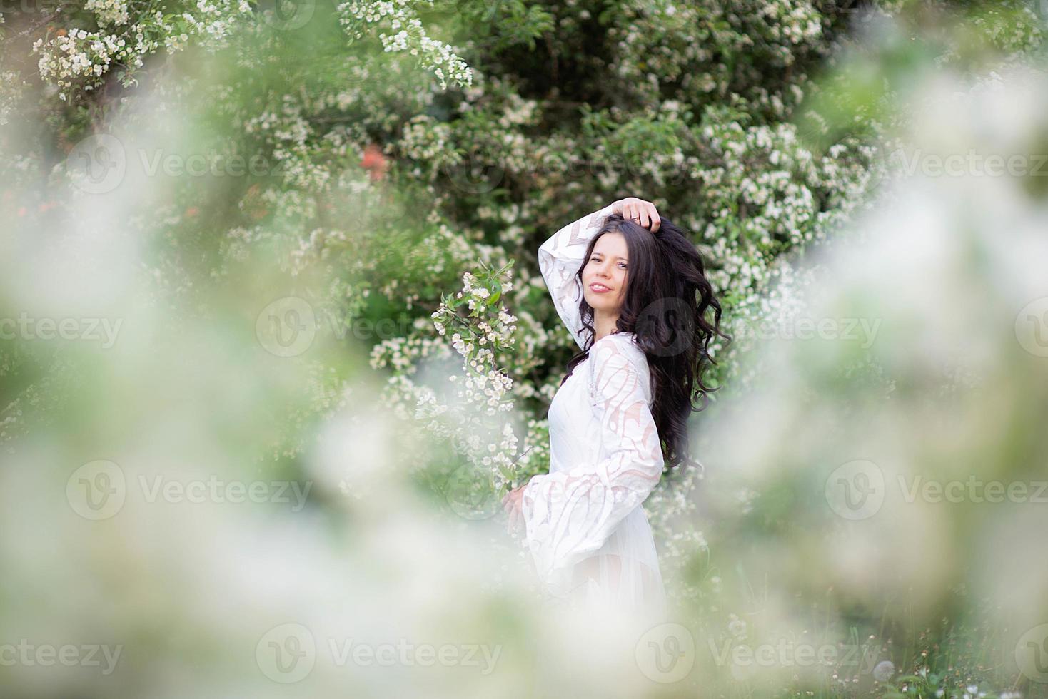 retrato, de, un, hermoso, mujer joven, en el parque, en, florecer, ramas foto