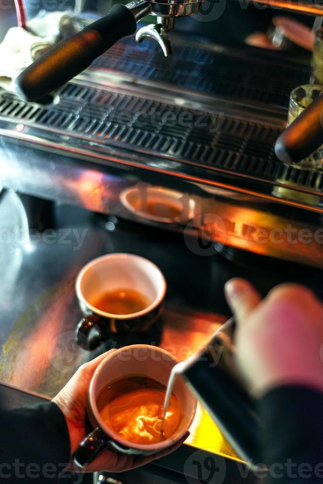 Hacer café espresso de cerca los detalles con la moderna máquina de café foto