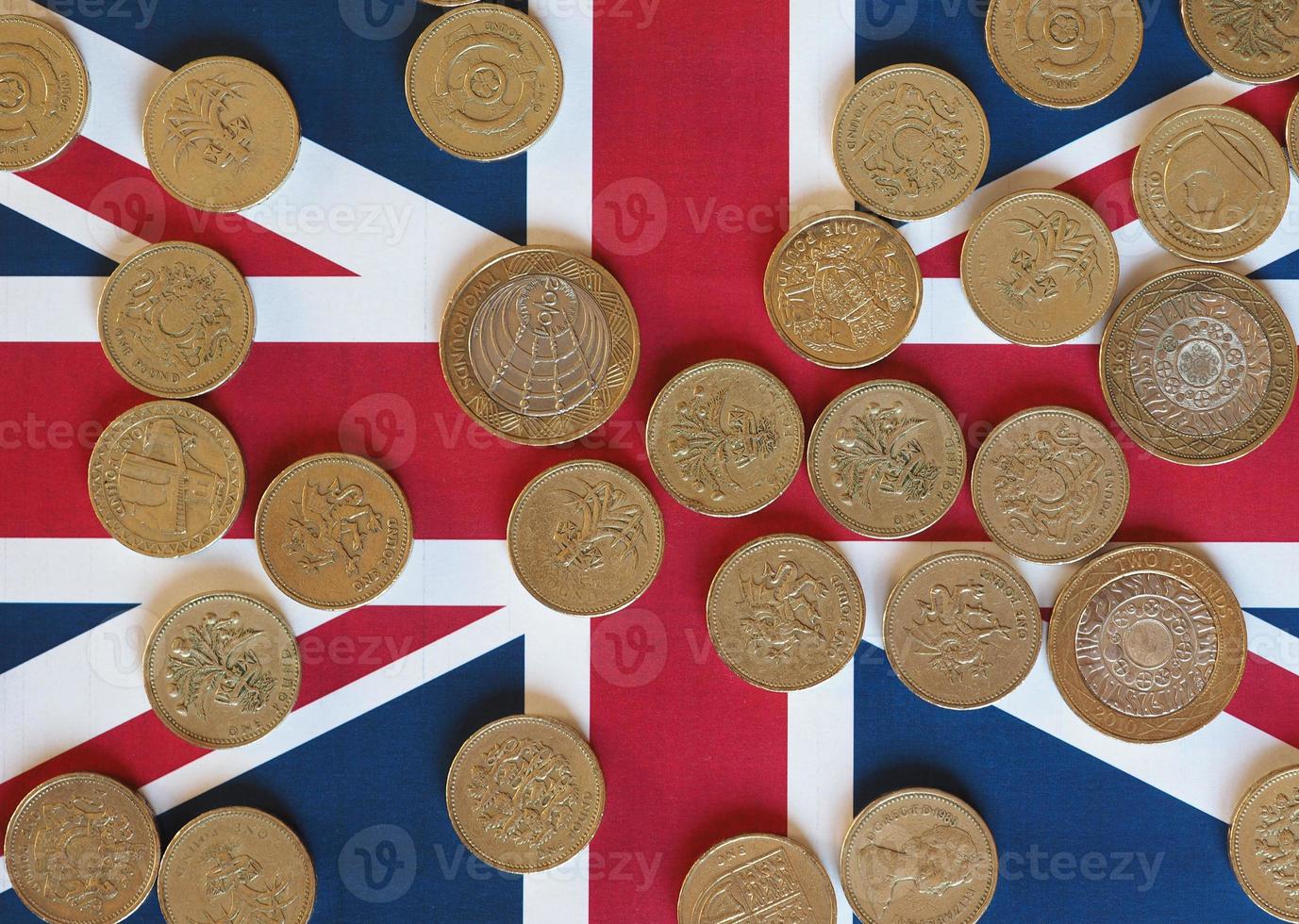 monedas de libra, reino unido sobre bandera foto