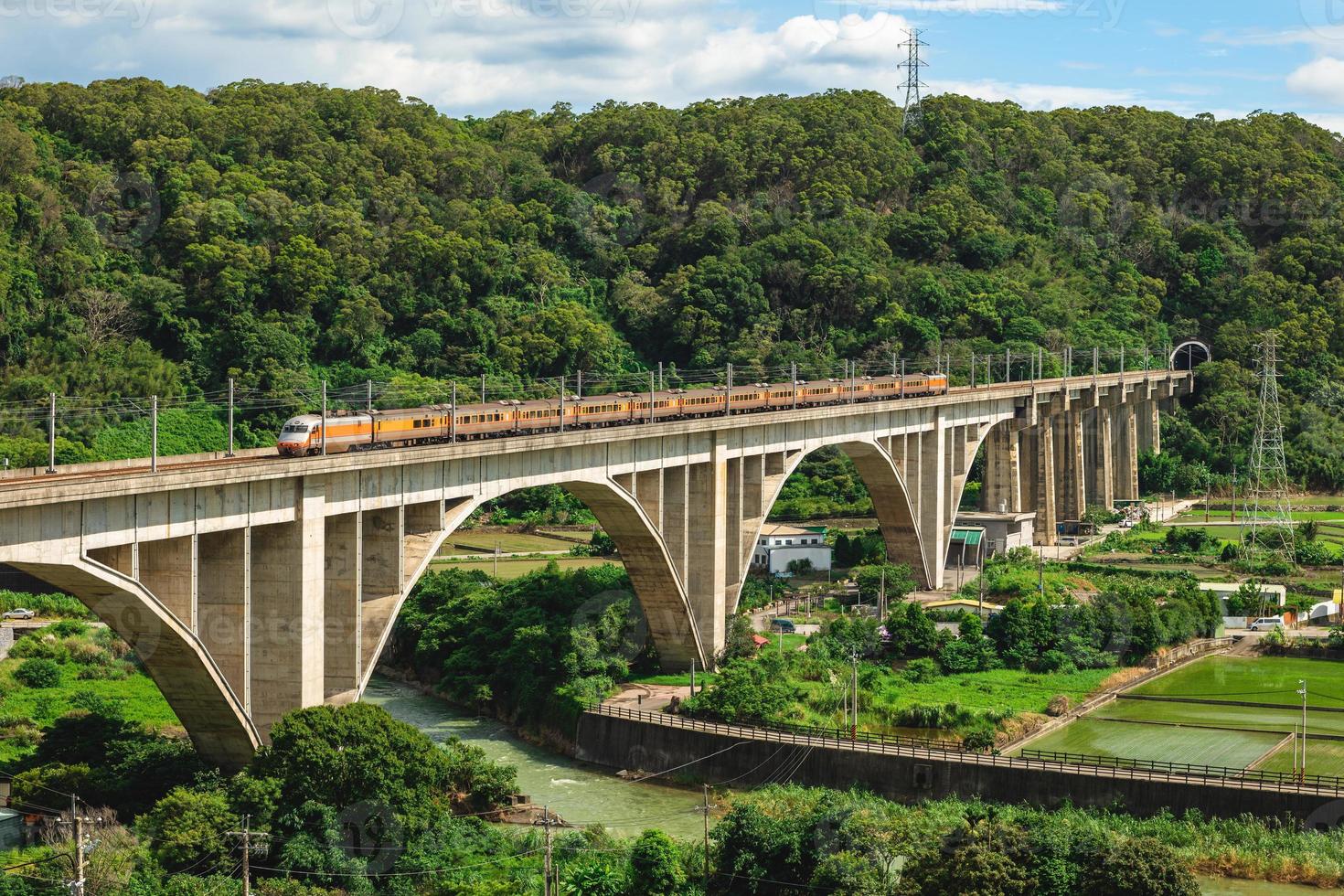 Un tren cruza el puente de arco de liyutan en miaoli, taiwán foto